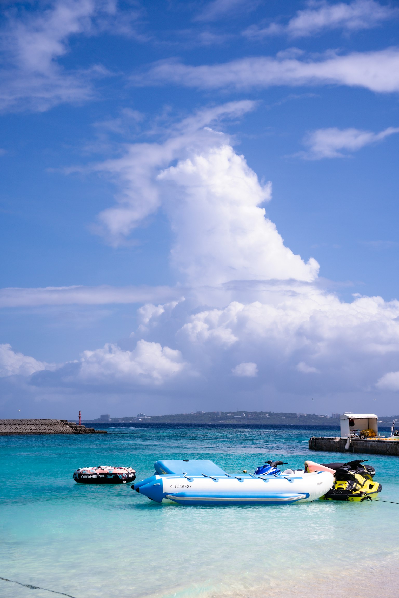 Boote, die auf blauem Meer unter einem Himmel mit weißen Wolken treiben
