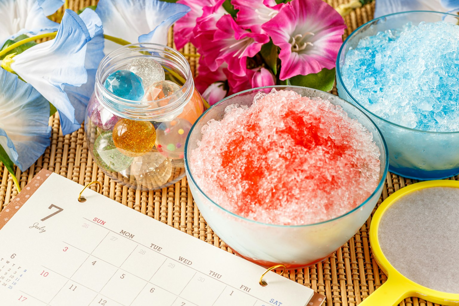 Bát đá bào nhiều màu với hoa và một cuốn lịch trên bàn