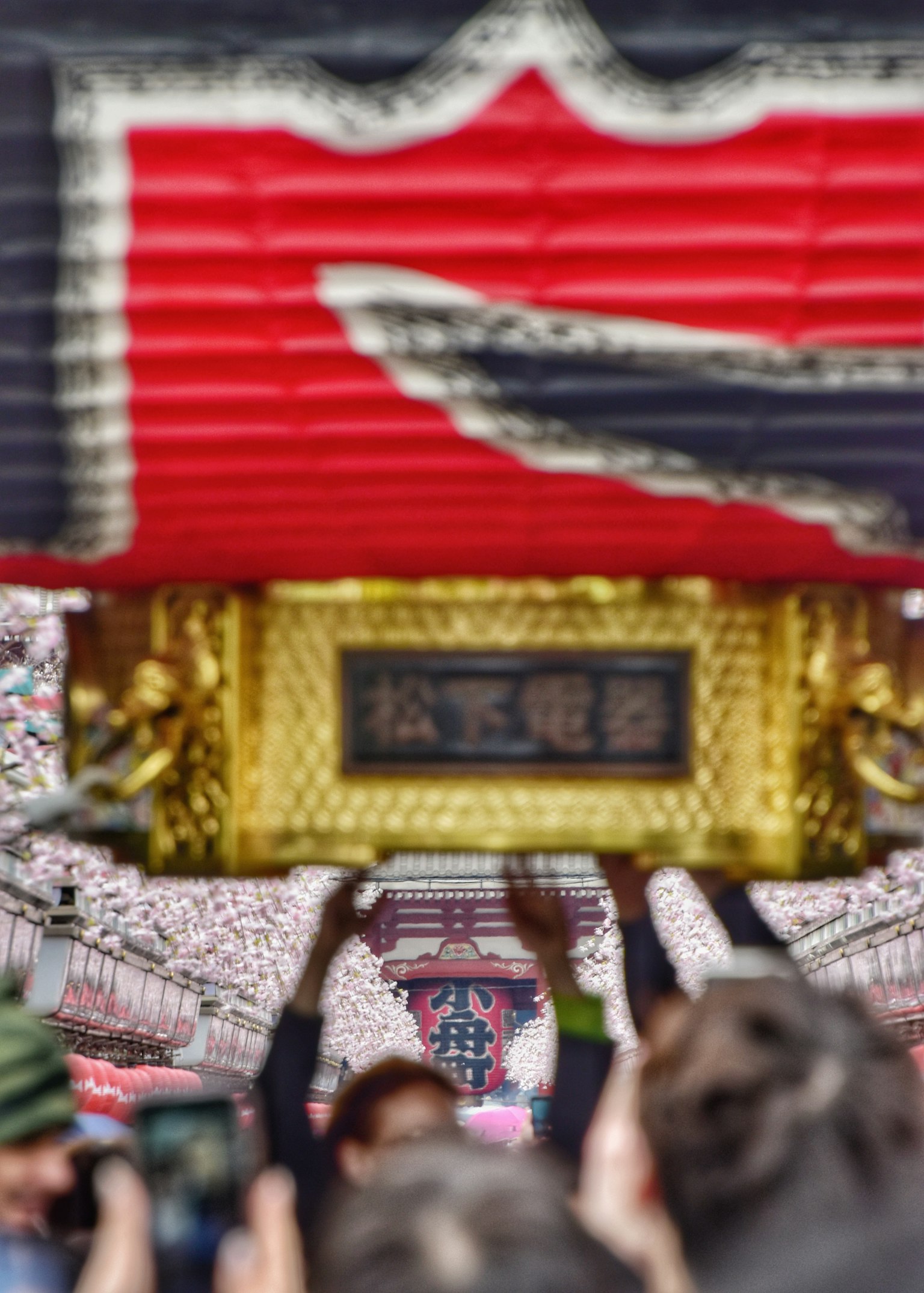 Vibrant festival scene with people holding a golden ornament and a red lantern in the background