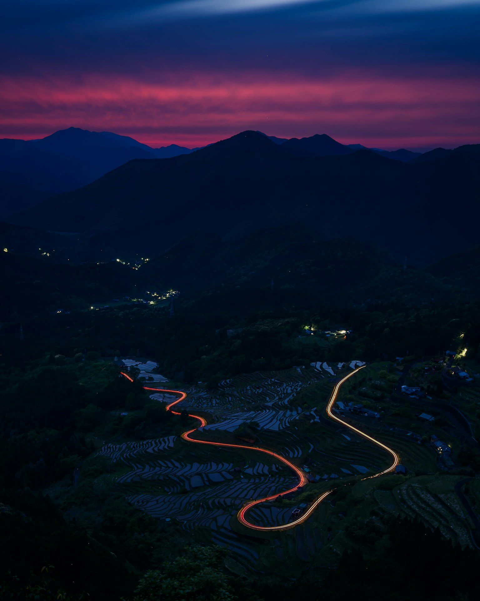 Scenic mountain landscape with winding road and vibrant sunset sky