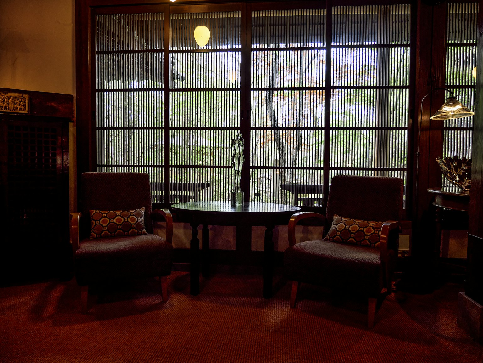 Espace intérieur confortable avec deux chaises et une table surplombant une vue verte à travers la fenêtre