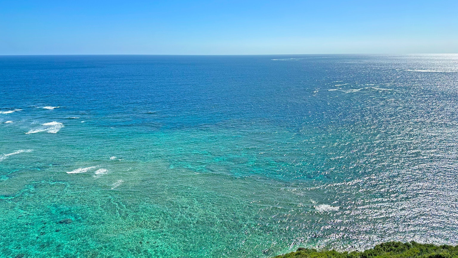 Vast blue ocean meeting clear sky with gentle waves