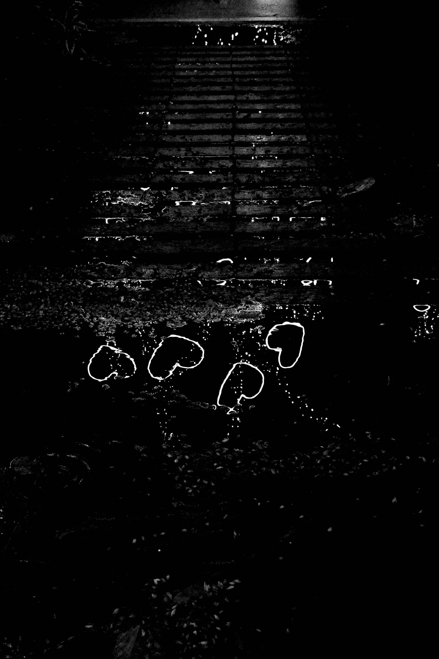 暗い背景に白いハート型の光が散らばる画像