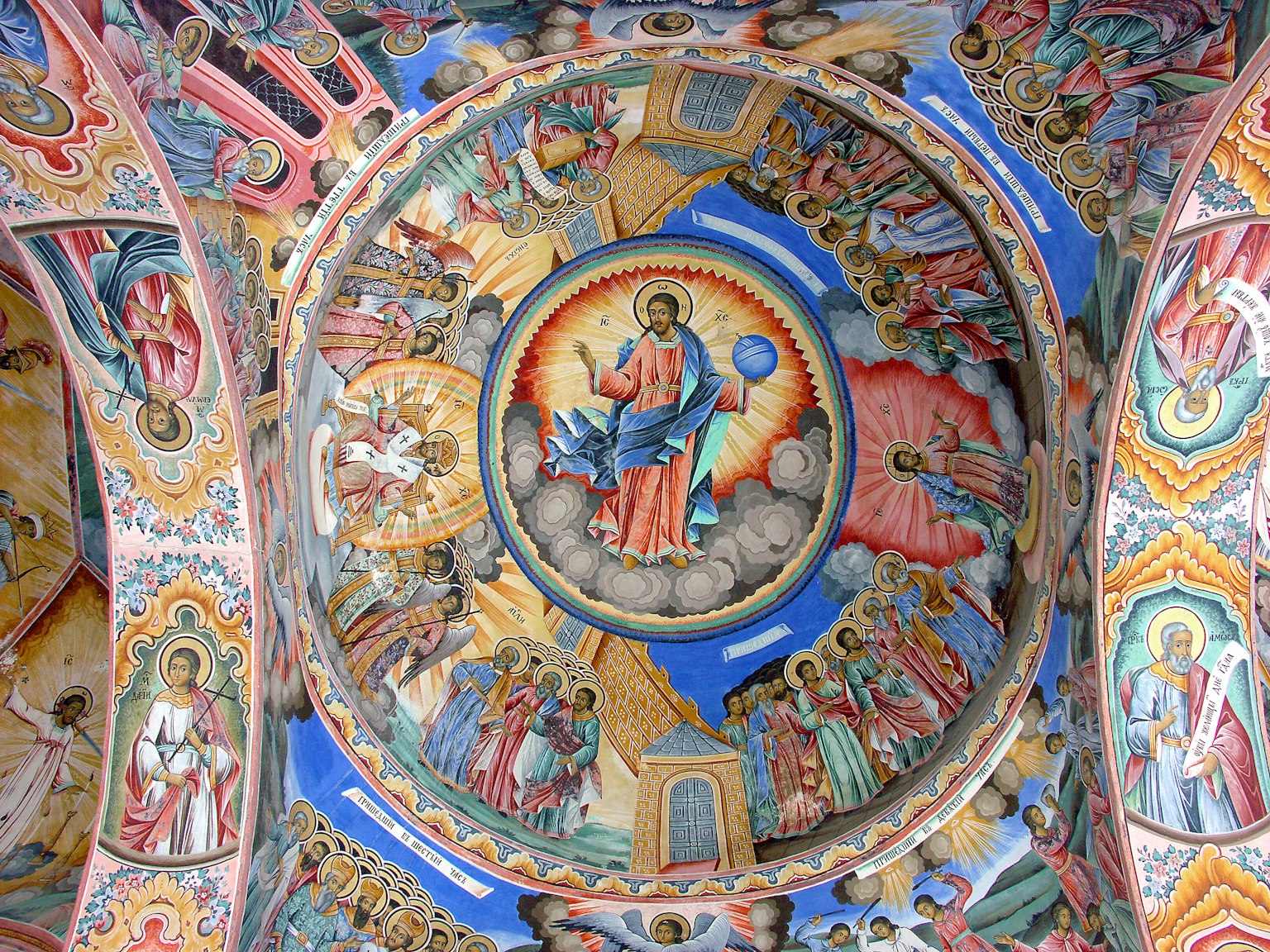 Fresco vibrante del techo de una iglesia con Cristo en el centro rodeado de imágenes de santos
