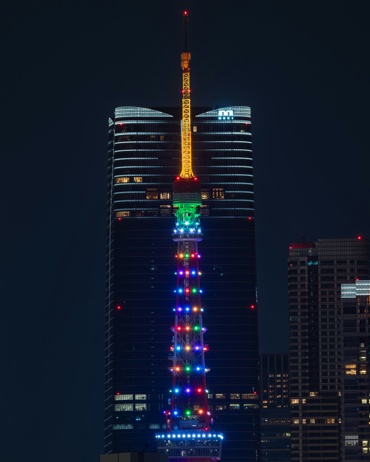 Menara Tokyo diterangi dengan lampu berwarna di malam hari