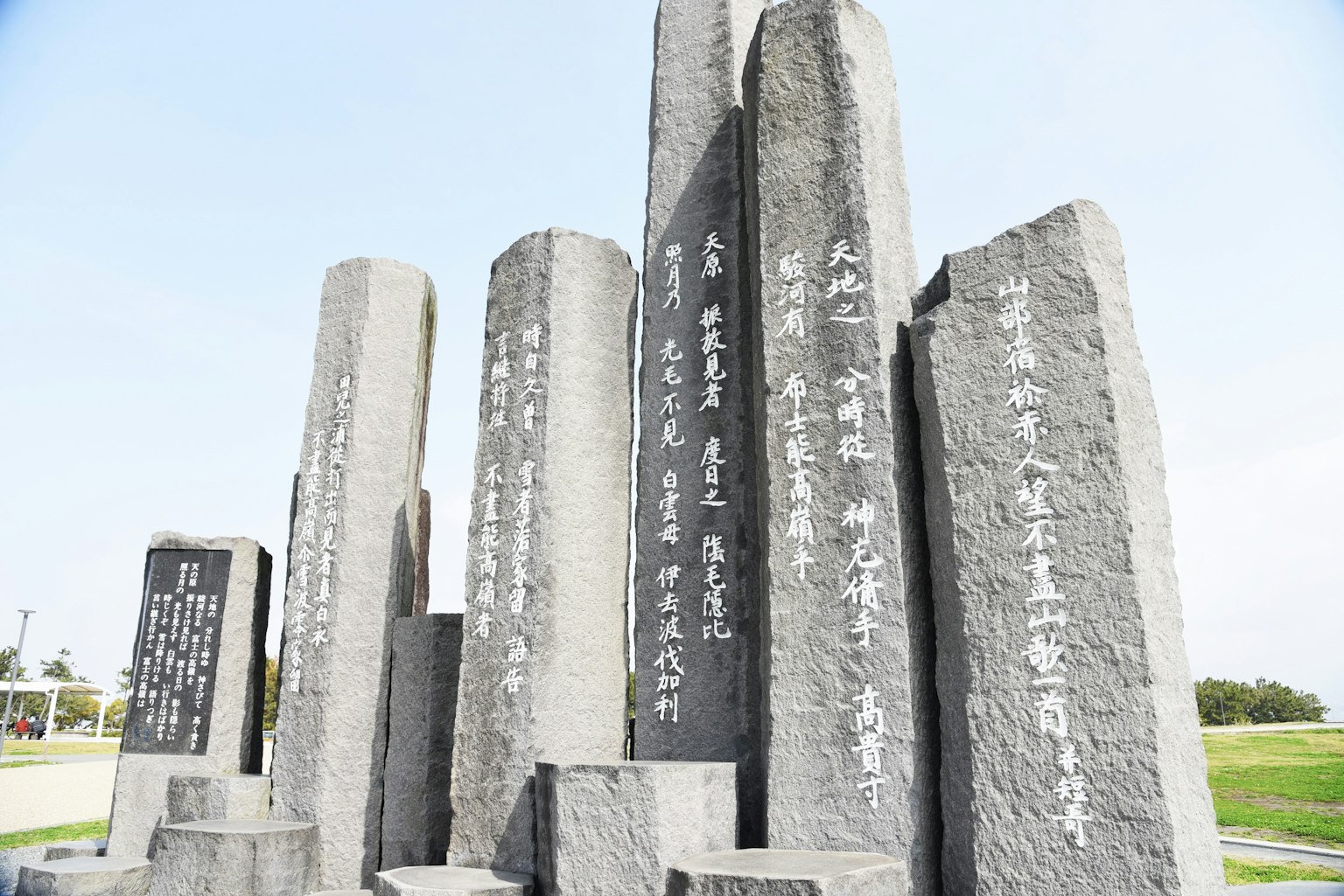 Un paesaggio con monumenti di pietra con iscrizioni sotto un cielo blu chiaro
