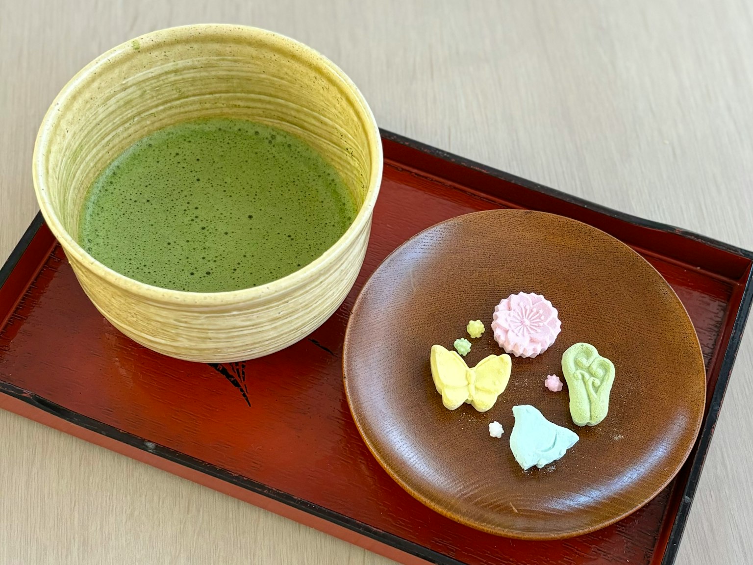 抹茶和多彩的日本甜點放在托盤上的圖片