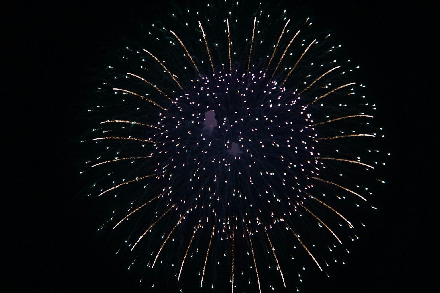 Una gran explosión de fuegos artificiales en el cielo nocturno con luces radiantes
