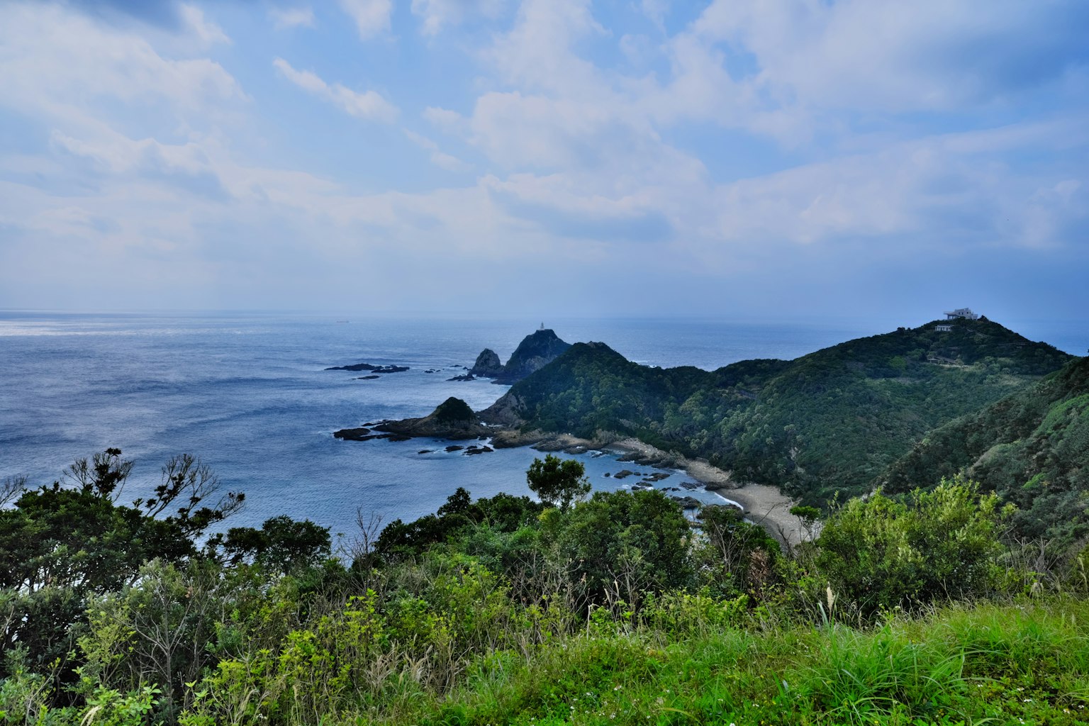 Scenic view of blue ocean and green mountains