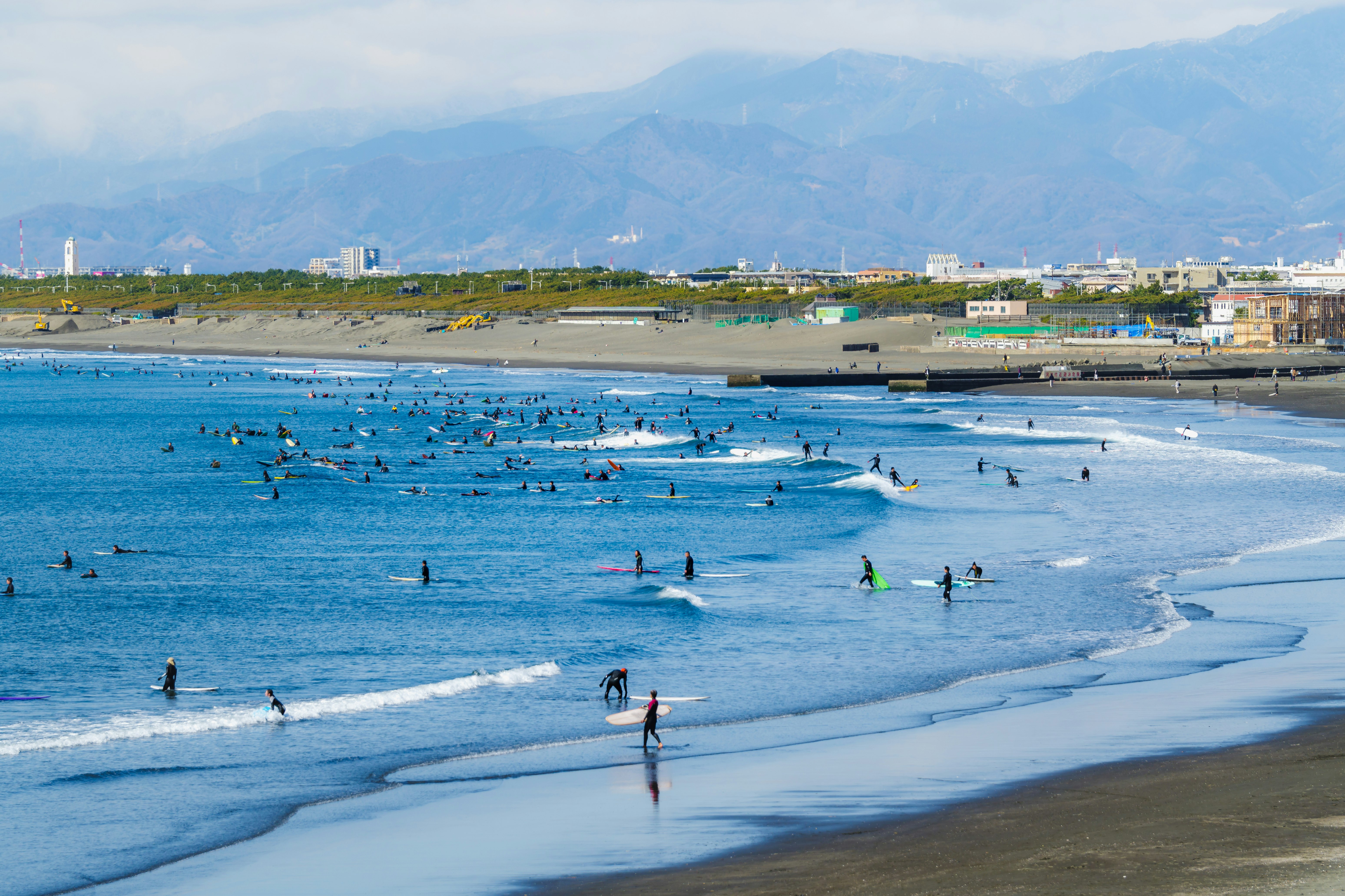 2月の片瀬海岸でサーファーが集う海辺の風景
