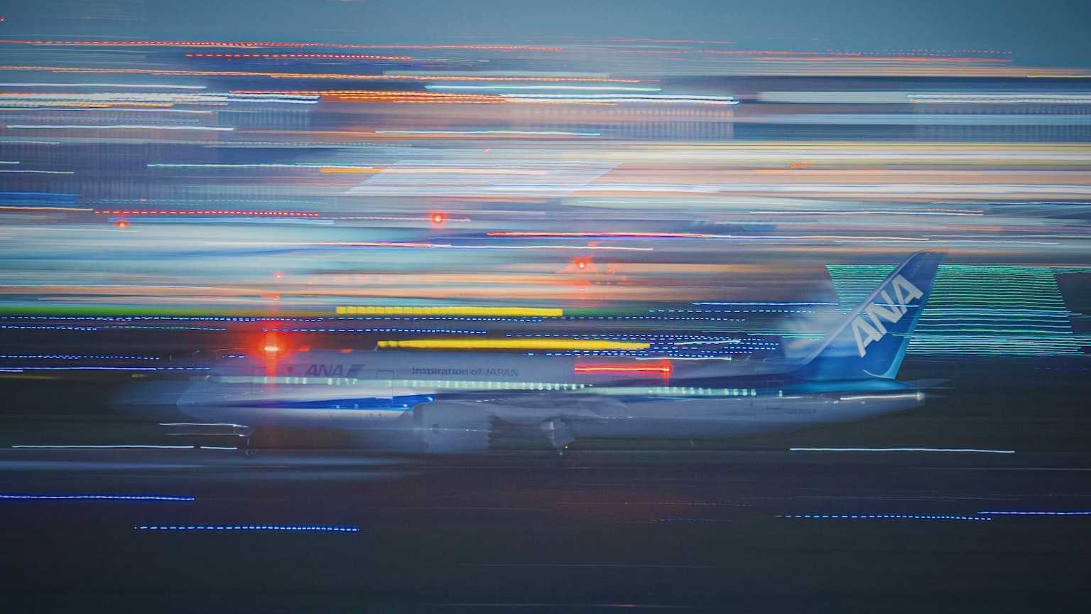 Avion bleu en mouvement sur la piste avec des traînées de lumière autour