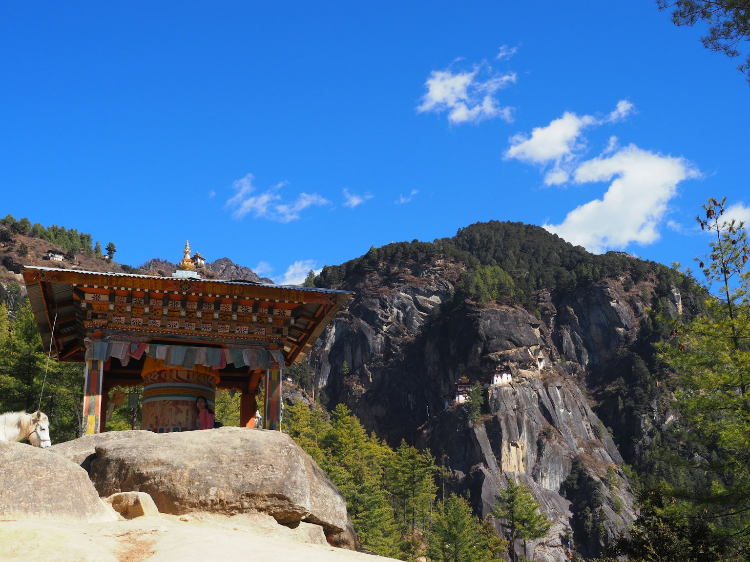 Menara lonceng Buddha tradisional dengan pegunungan megah dan langit biru