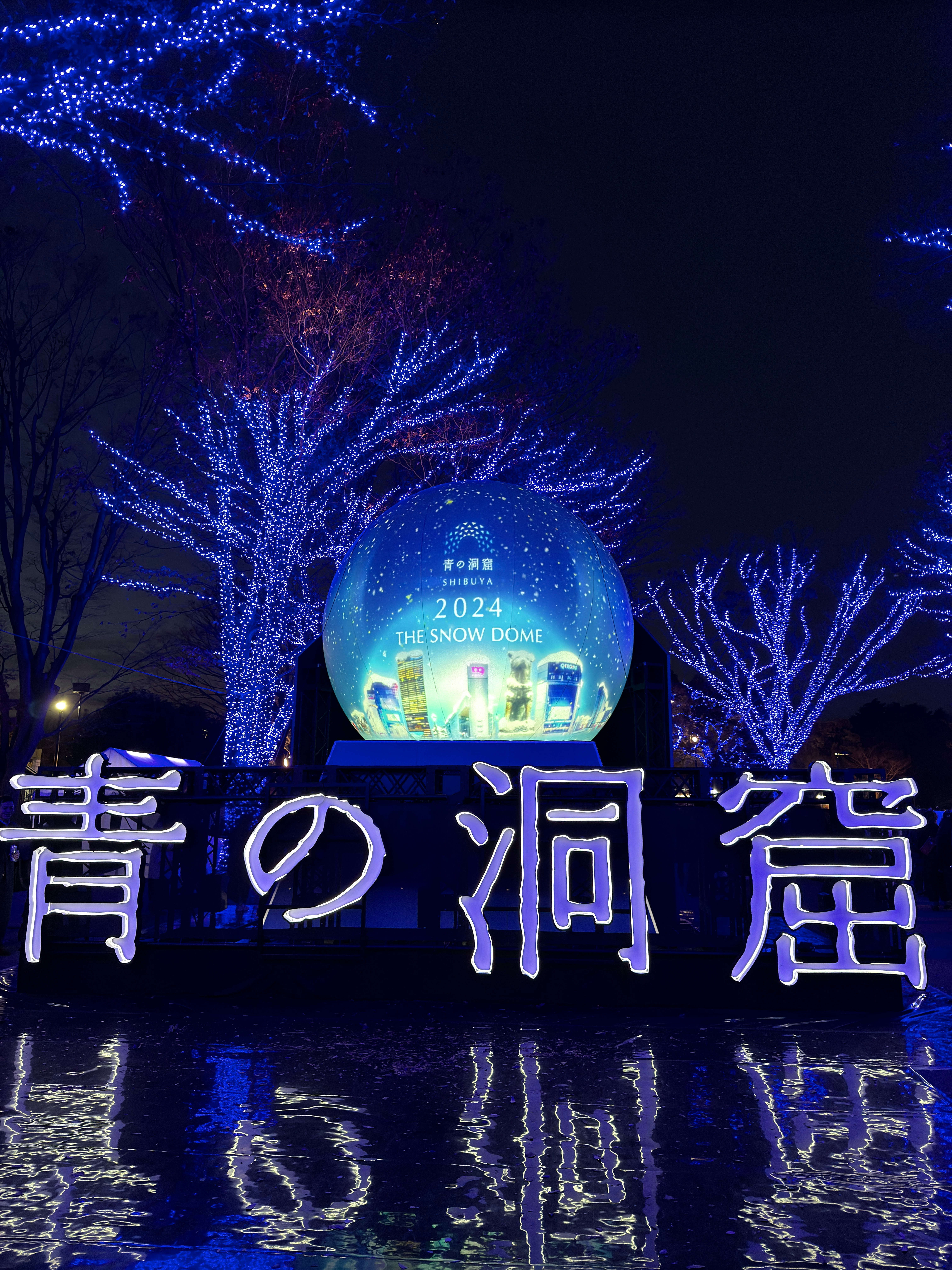 青いイルミネーションのガラス球と噴水のある夜の看板