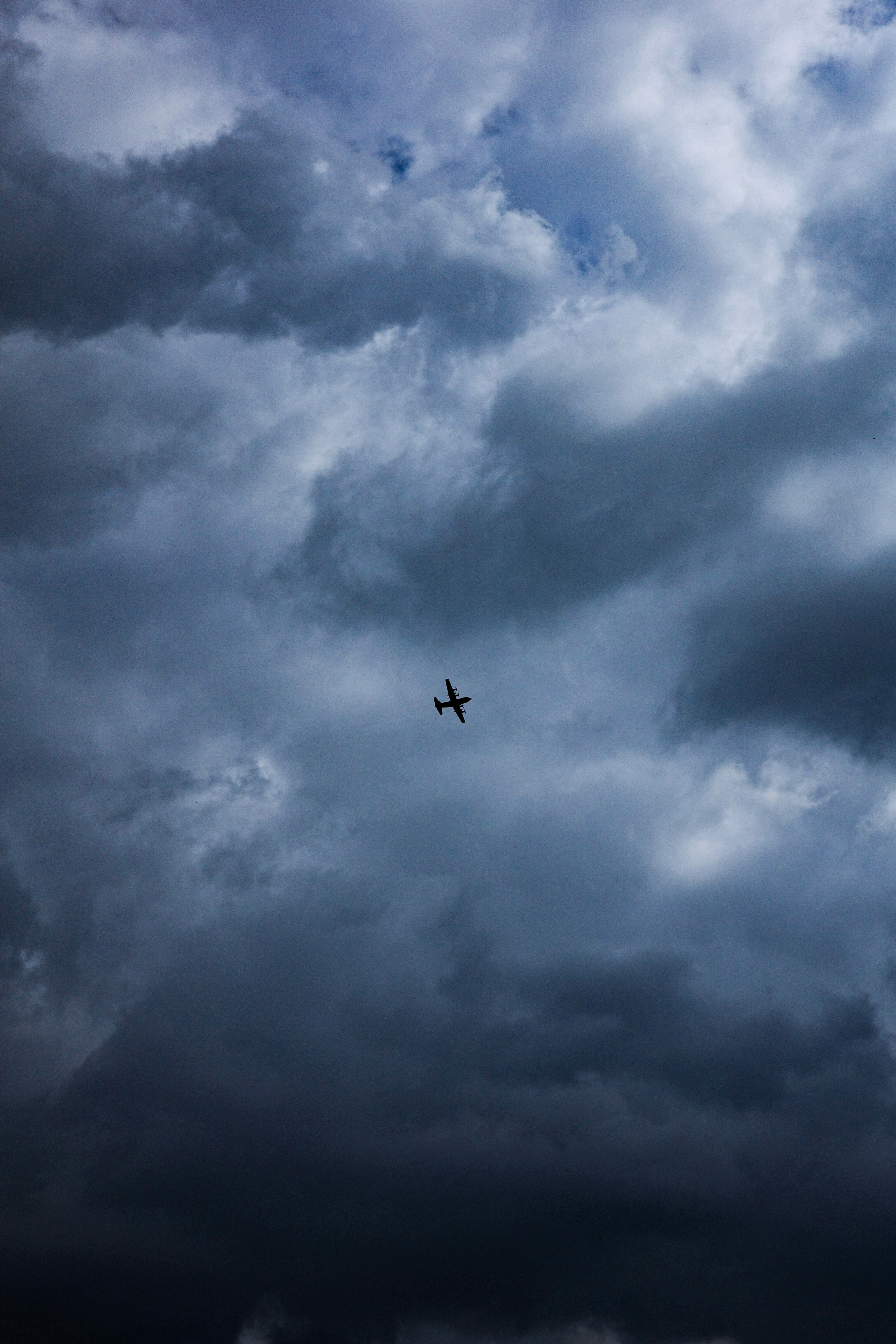 雲層密佈的天空中，一架飛機掠過