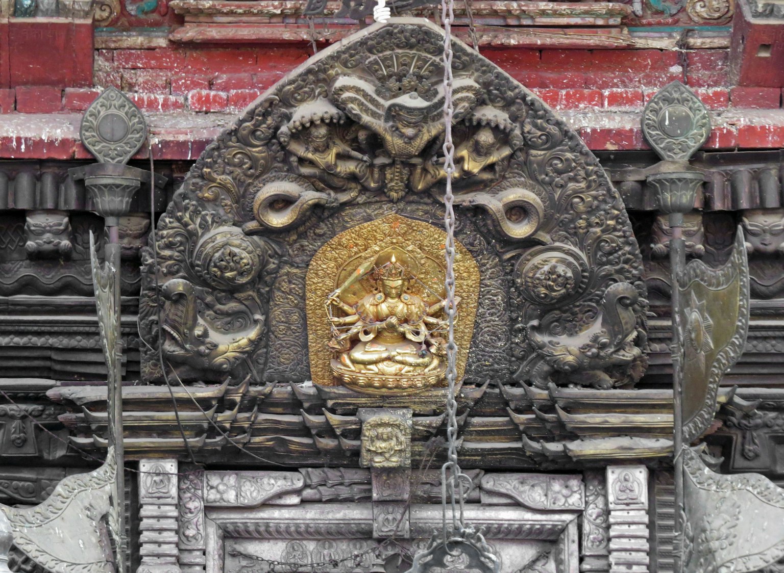 Golden deity statue with intricate carvings in a temple decoration