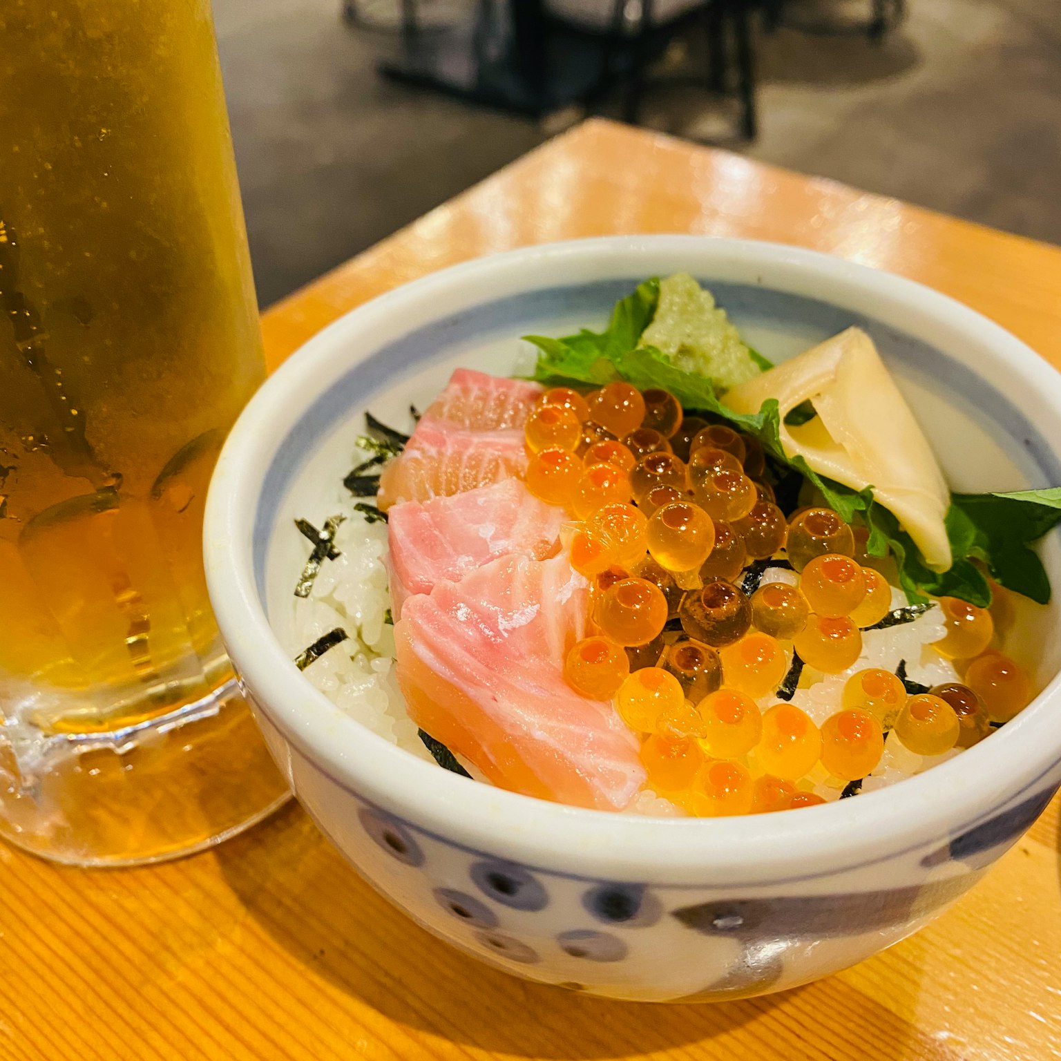 Leckere Meeresfrüchte-Schüssel mit Lachs und Fischrogen neben einem Glas Bier