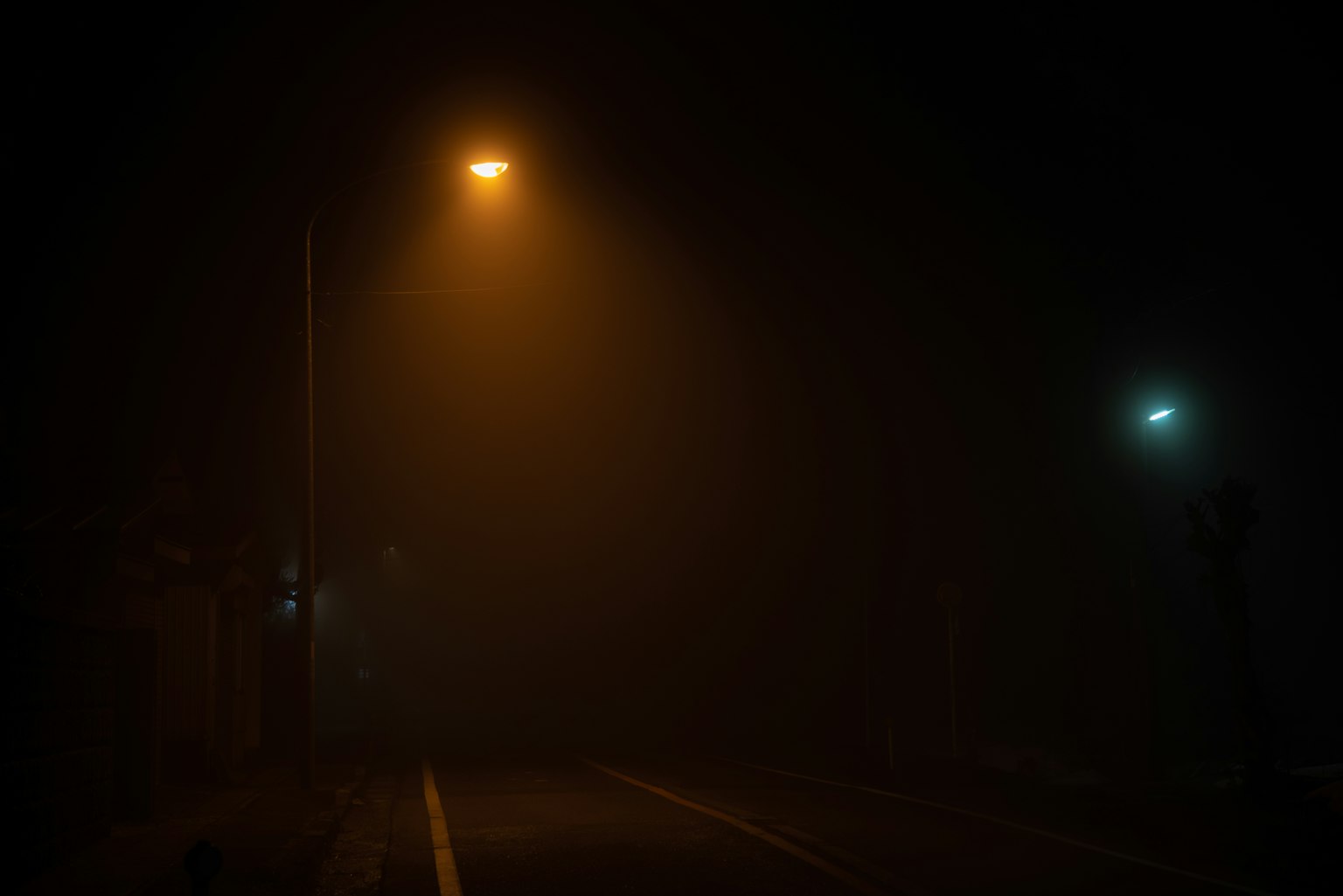 Straße, die bei Nebel von Straßenlaternen beleuchtet wird