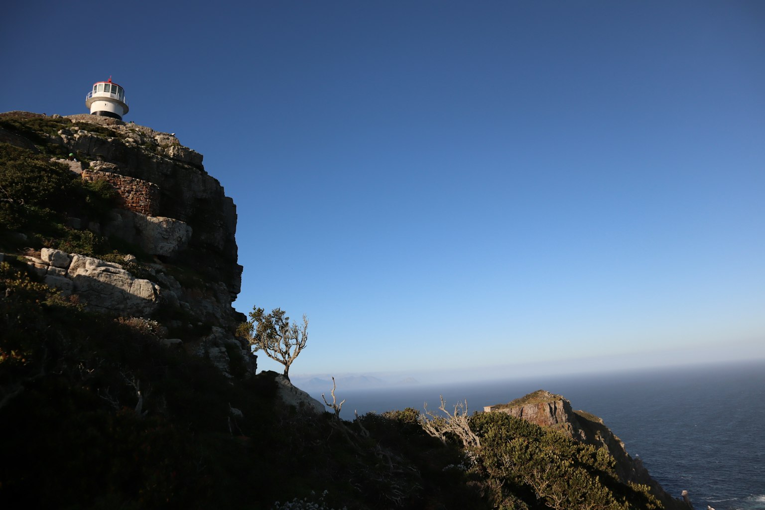 海岸燈塔的風景，位於岩石懸崖上，清澈的藍天和海洋