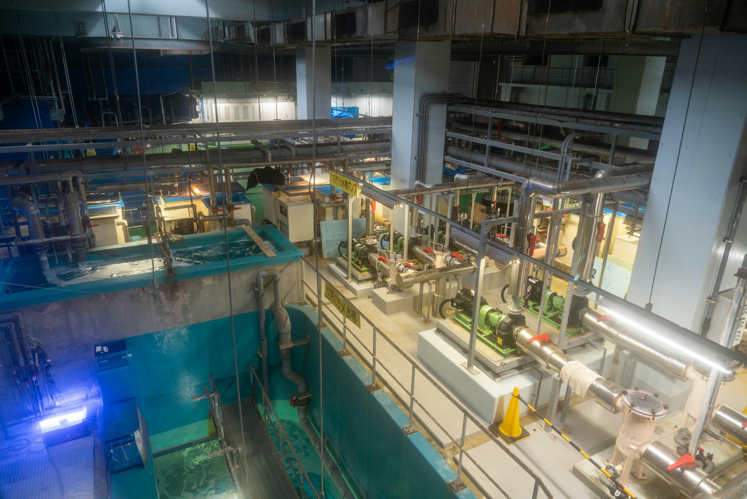 Vue intérieure d'une usine montrant des machines et un réseau de tuyauterie