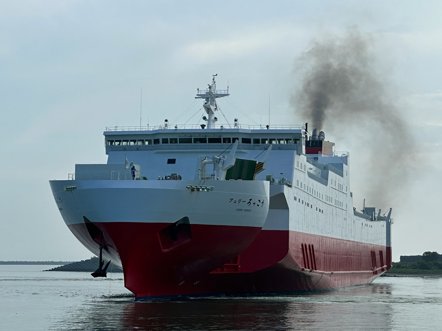 Nave rossa e bianca che emette fumi mentre si dirige verso il mare