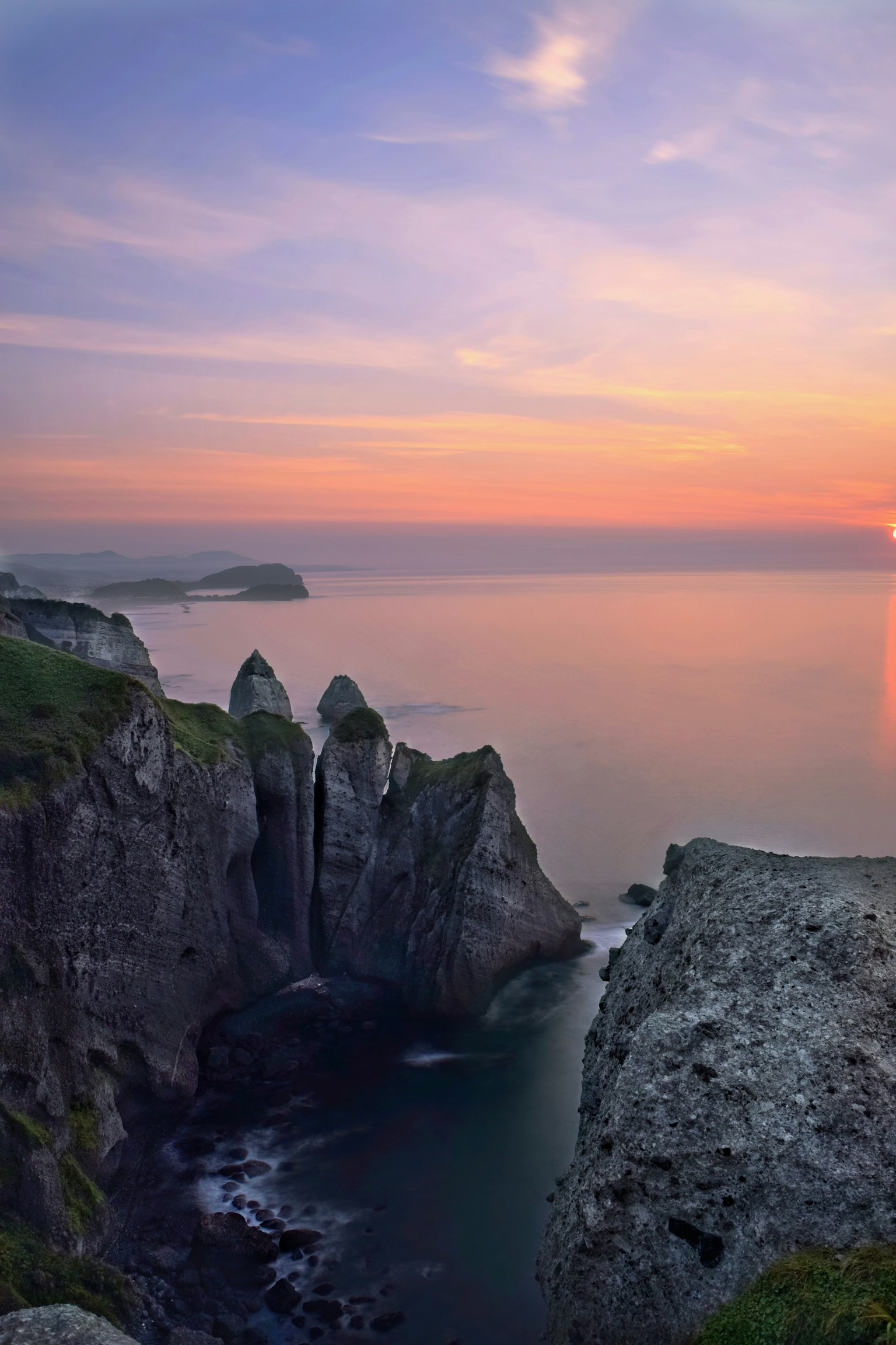 Coastal cliffs with a vibrant sunset sky over the ocean