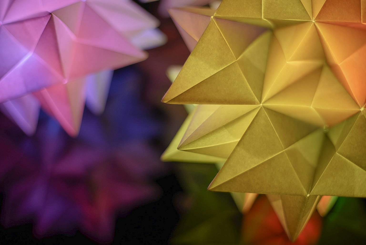 Lampu berbentuk bintang origami berwarna-warni dengan latar belakang kabur