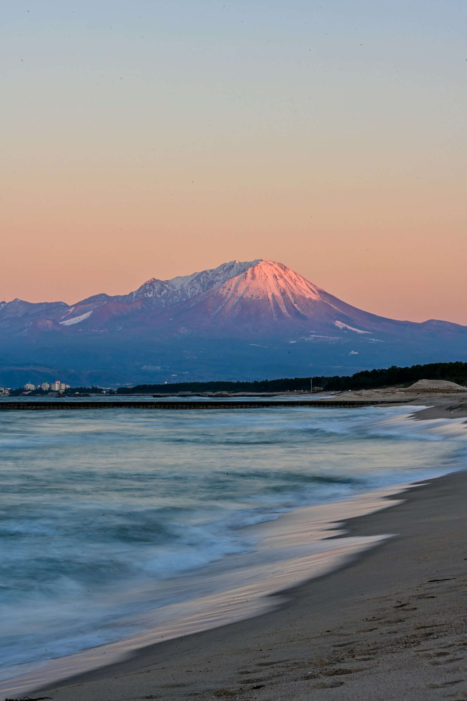 日落时分海岸线上的雪山