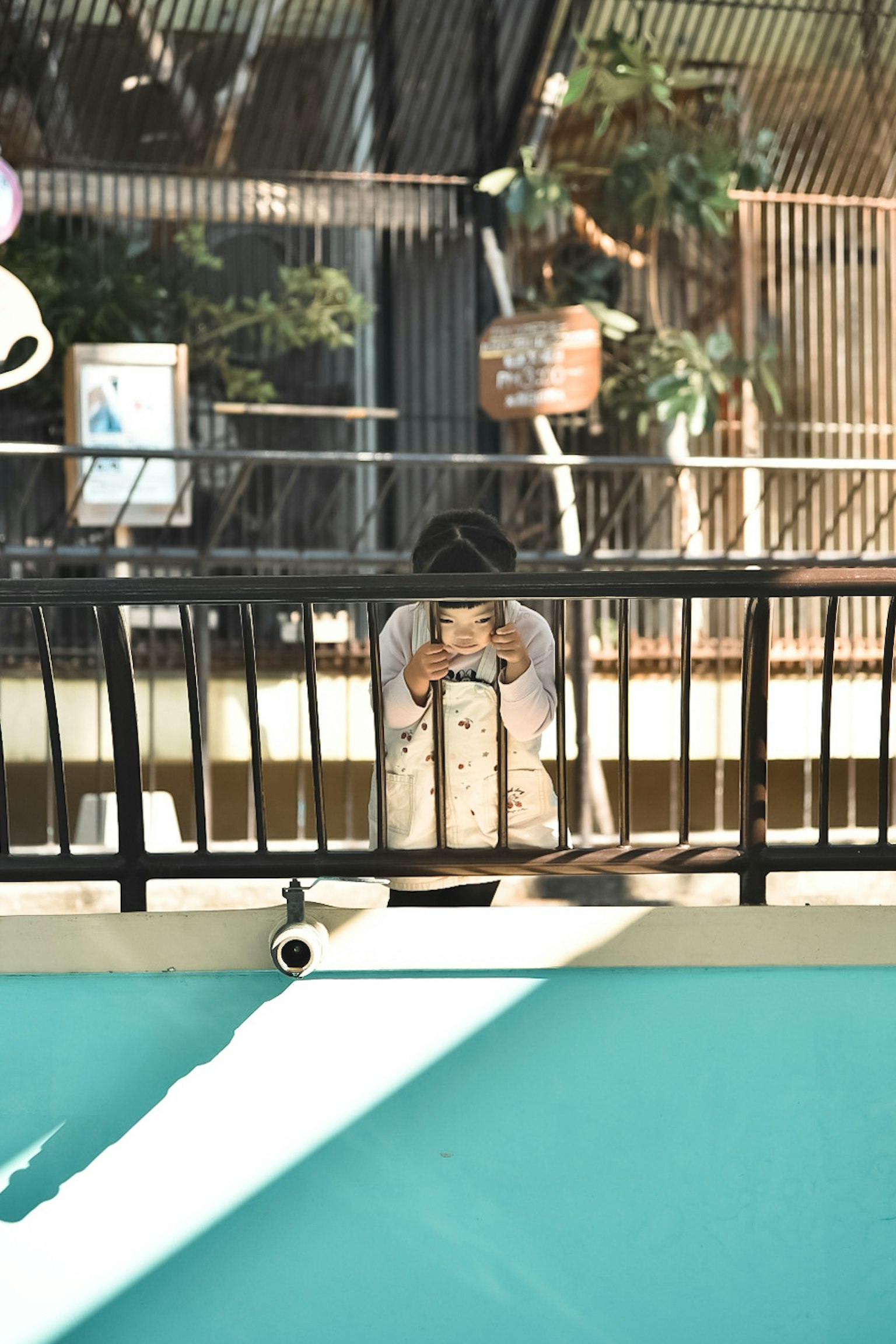 A child holding a camera by the water