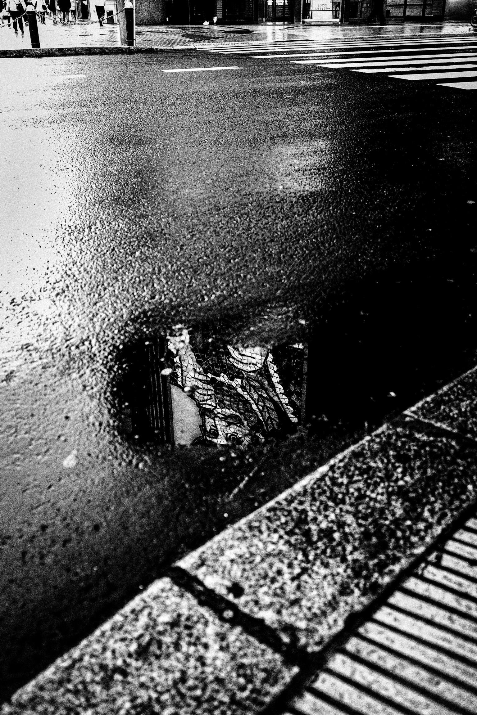Reflejo de un edificio en un charco en una calle de la ciudad después de la lluvia