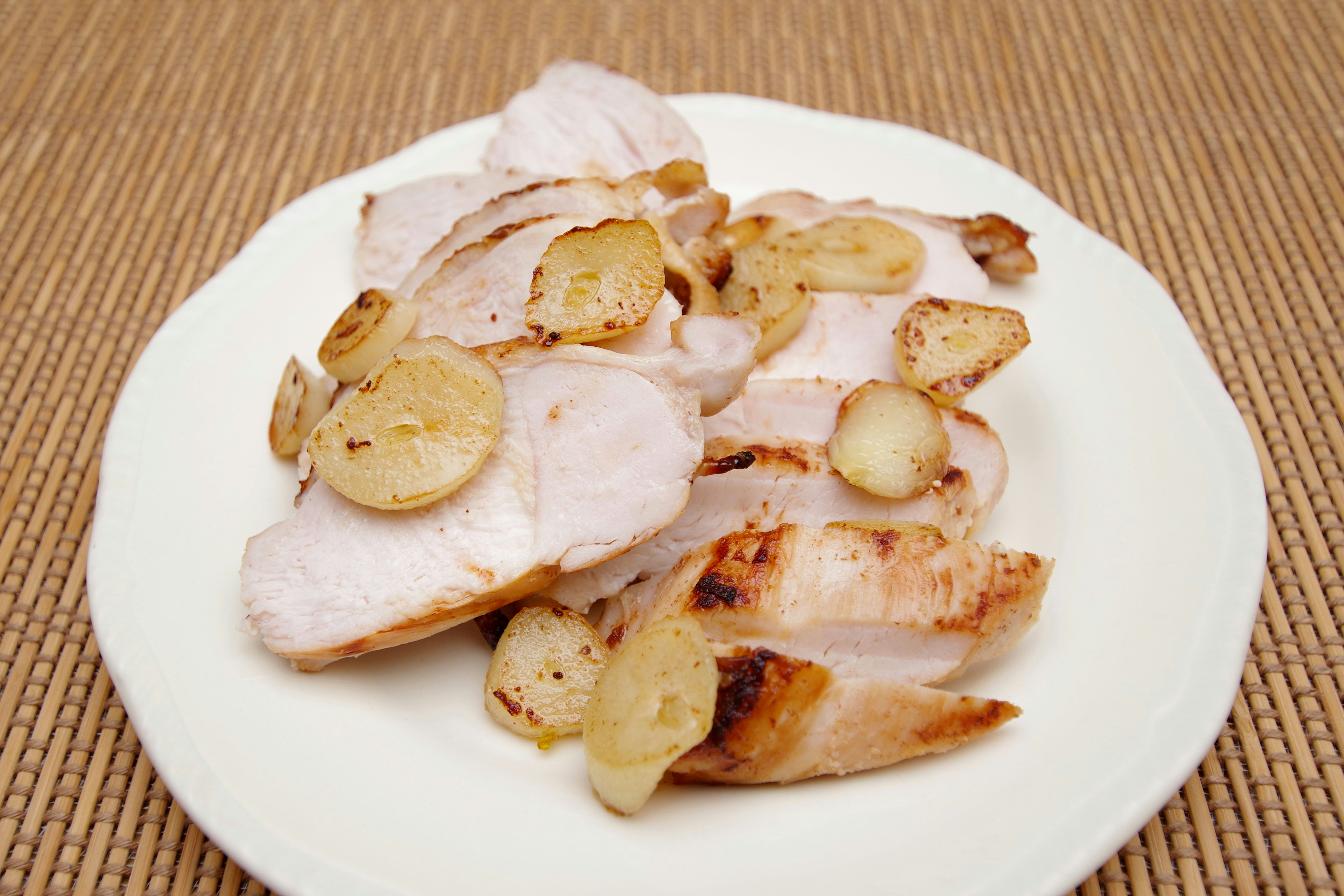 porc grillé aux tranches d’ail dans une assiette blanche