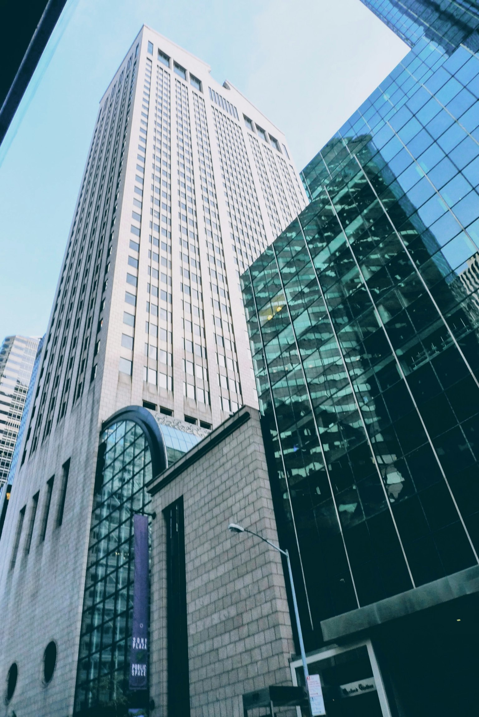Urban landscape featuring a towering skyscraper under a clear blue sky