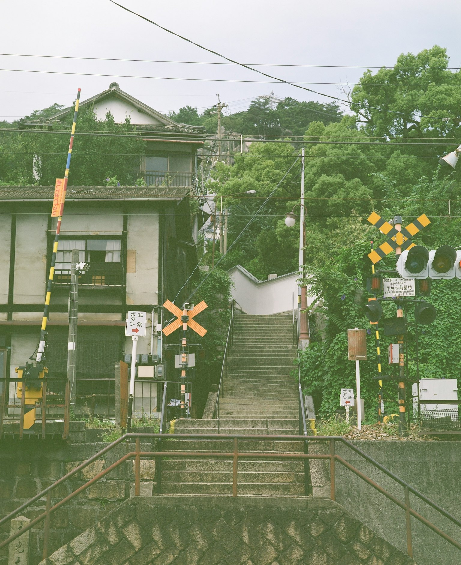 Treppen, die zu einem Bahnübergang mit traditionellen Gebäuden führen