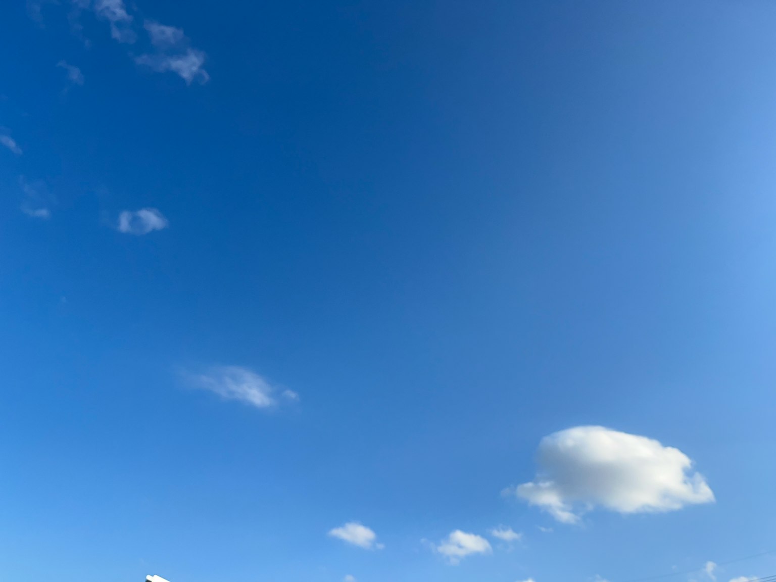 Bright blue sky with scattered white clouds