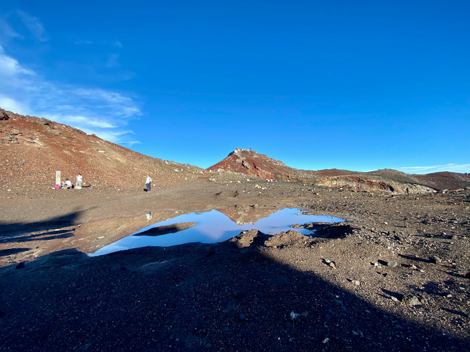 Paisaje volcánico con nieve restante y cielo azul claro