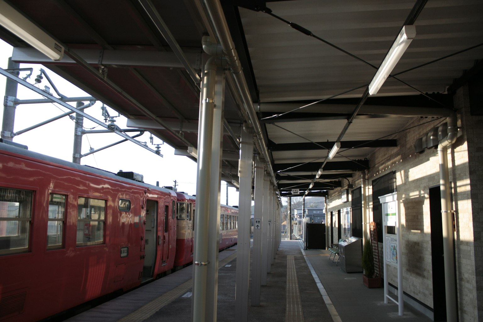 Blick auf einen Bahnsteig mit einem roten Zug an einer Station