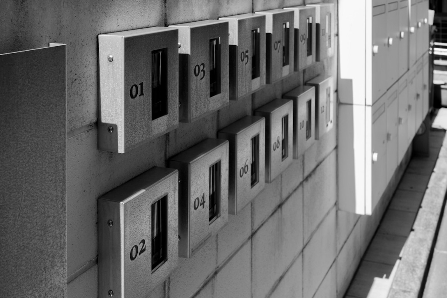 Immagine di un muro con cassette postali in bianco e nero disposte