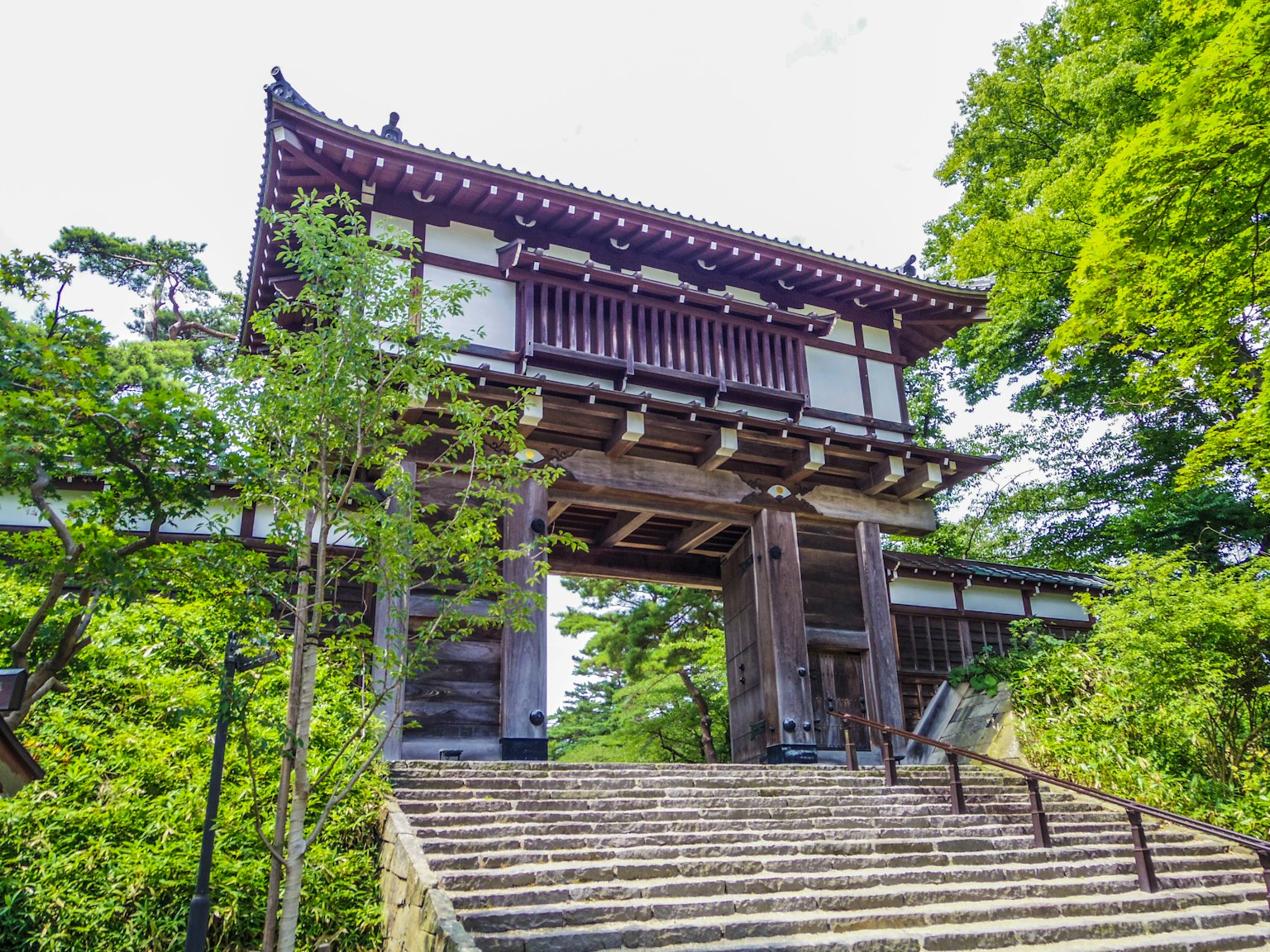 Porte japonaise traditionnelle entourée d'une verdure luxuriante