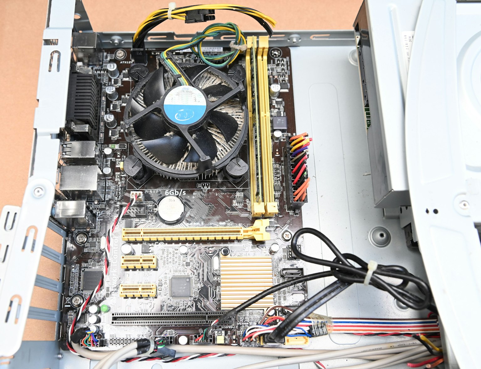 Gambar menunjukkan motherboard komputer dengan kipas pendingin dan kabel