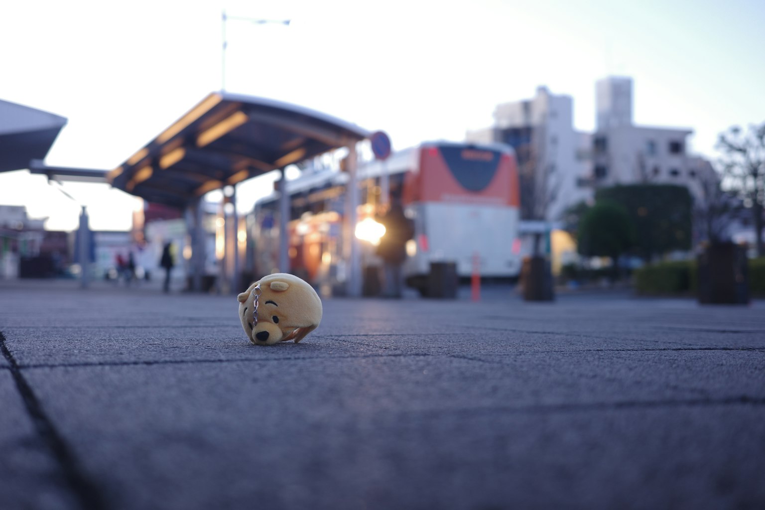 A small object on the sidewalk in front of a station with buildings in the background