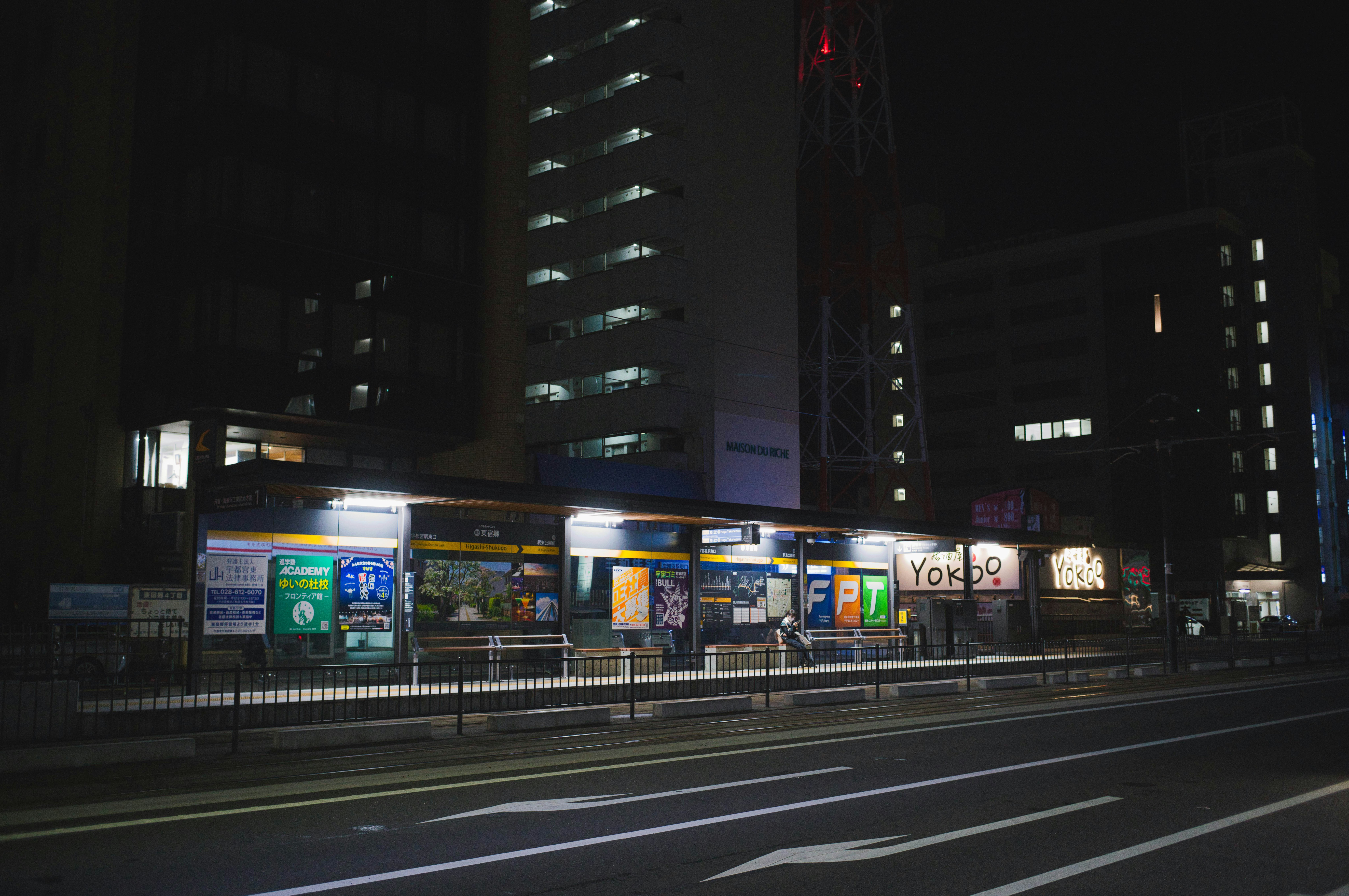 夜の幹線道路沿いに並ぶ看板とビル群