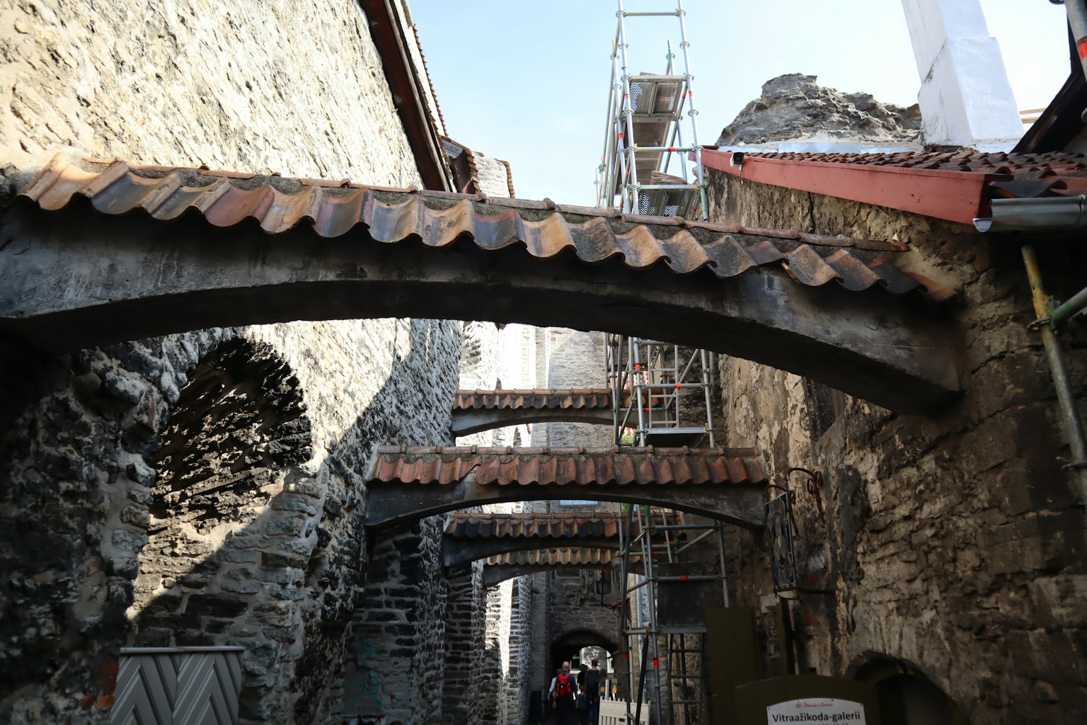 Blick auf eine enge Straße mit alten Steingebäuden und Bogenbrücken