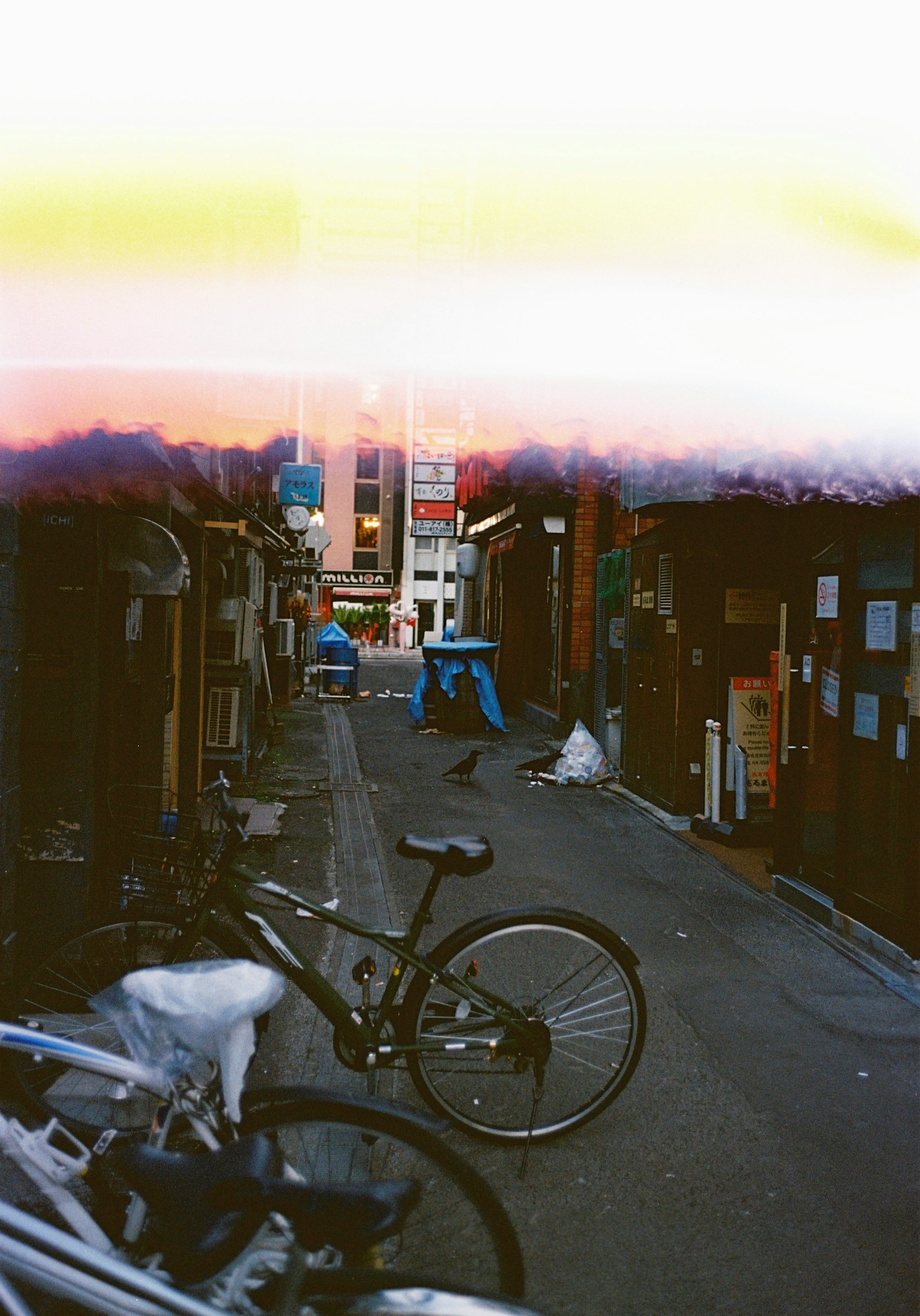 狭い路地に自転車が置かれた風景と背景に人がいる