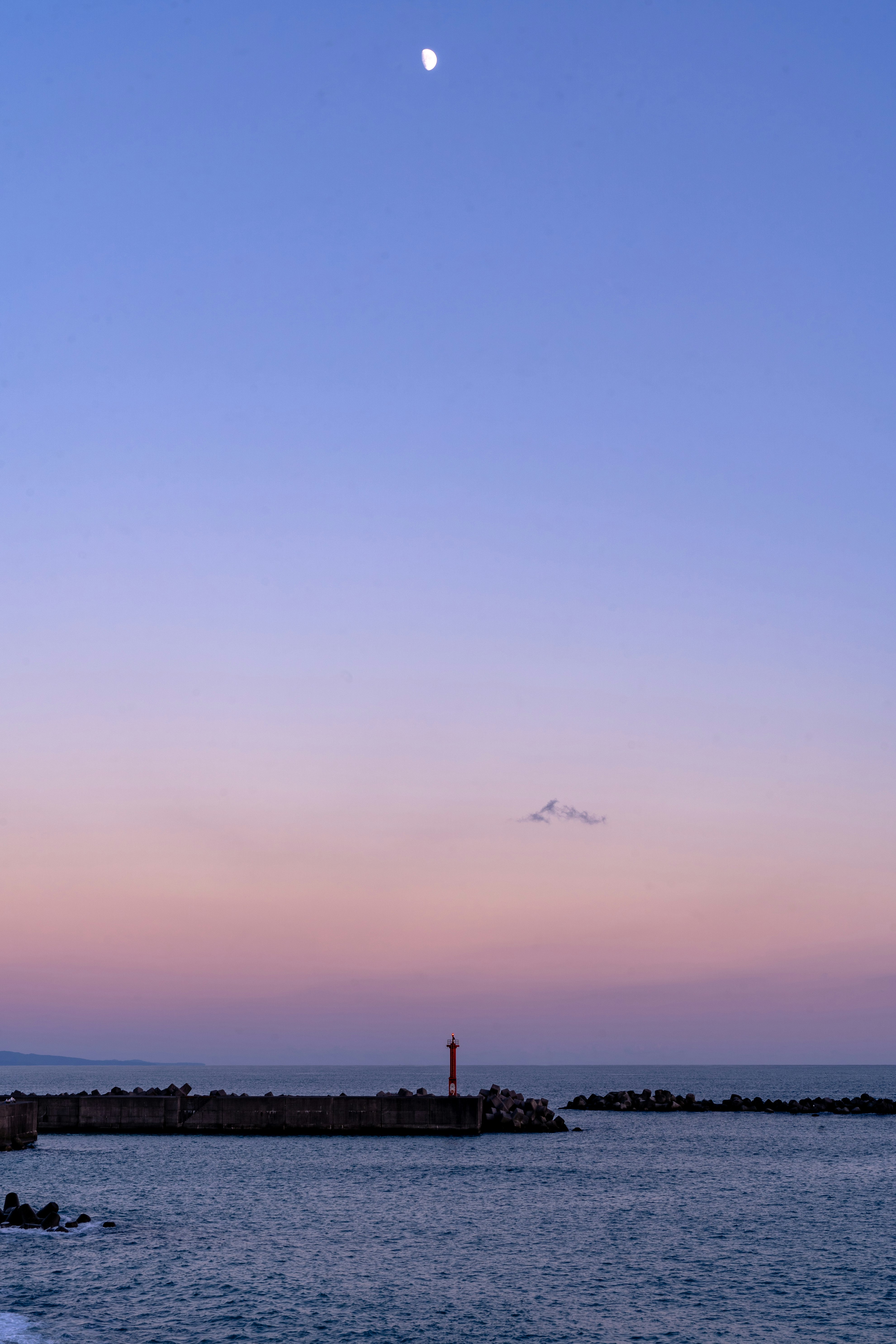 桟橋と防波堤のある海辺の夕暮れ空
