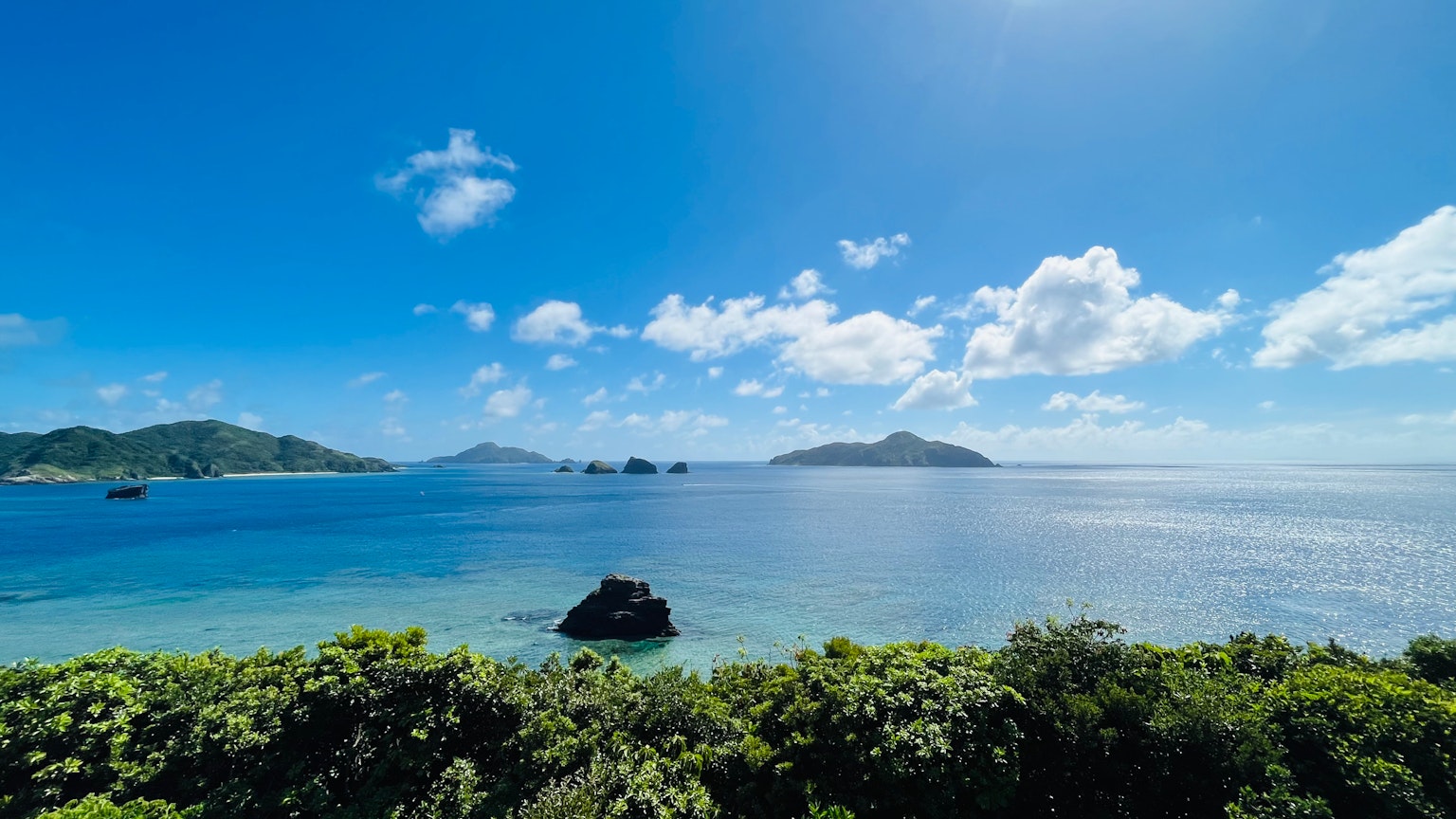 Magnifique paysage de mer et ciel bleus avec de la verdure au premier plan et des îles au loin