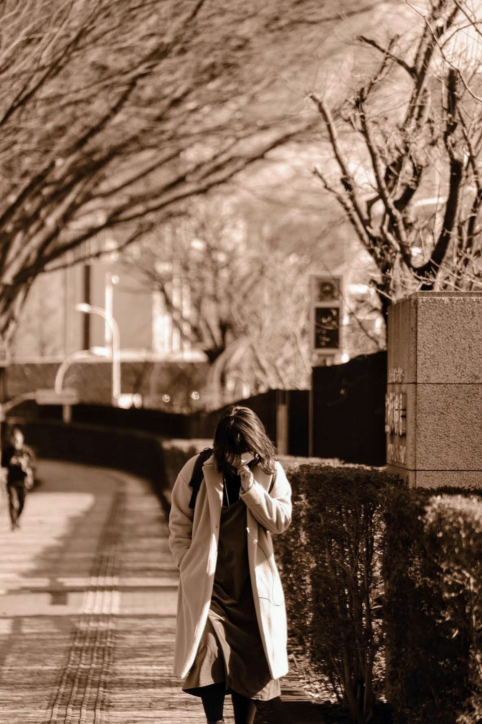 Una mujer con un abrigo blanco caminando por una calle de la ciudad