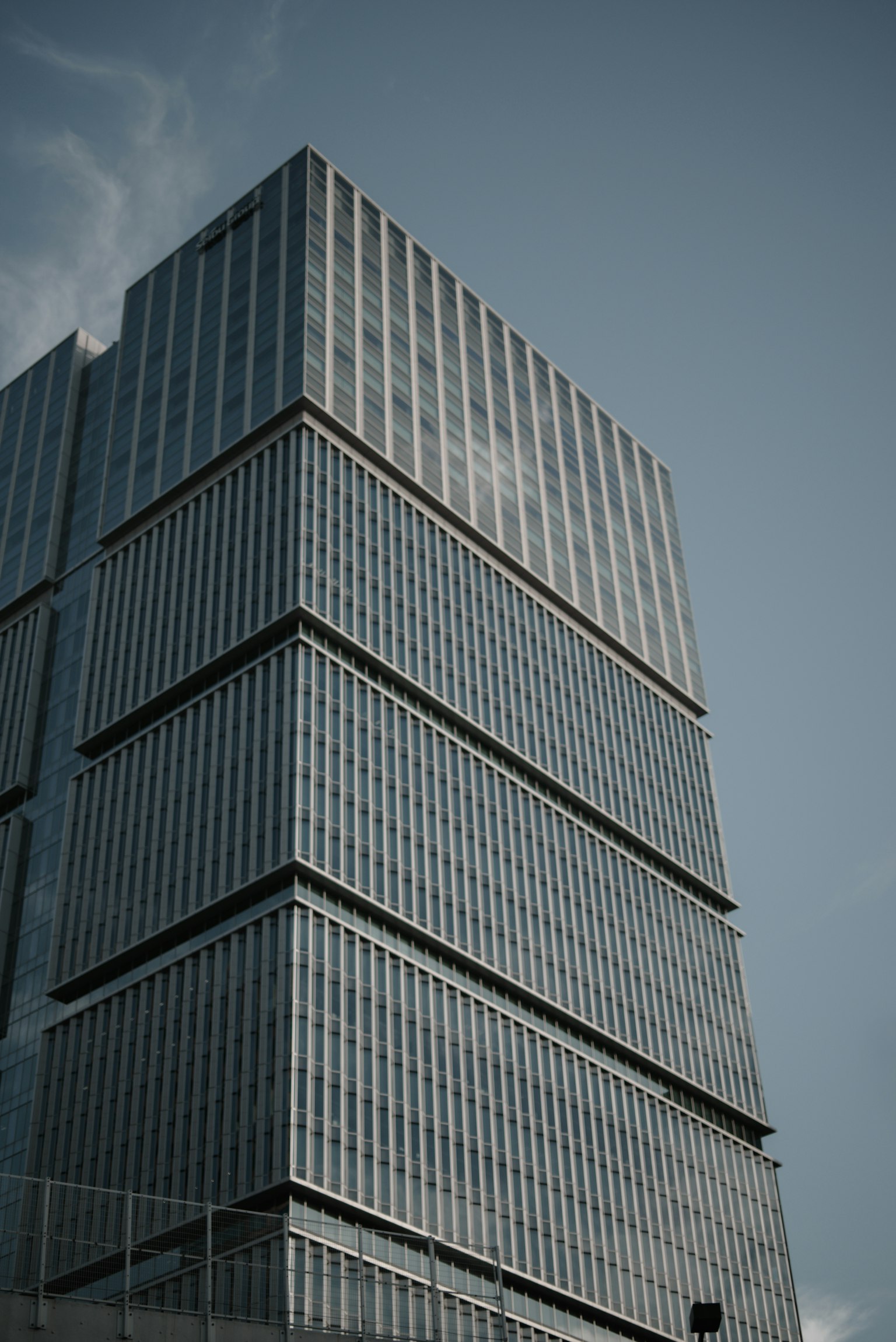 Gedung modern dilihat dari sudut diagonal menyoroti fasad kaca dan garis
