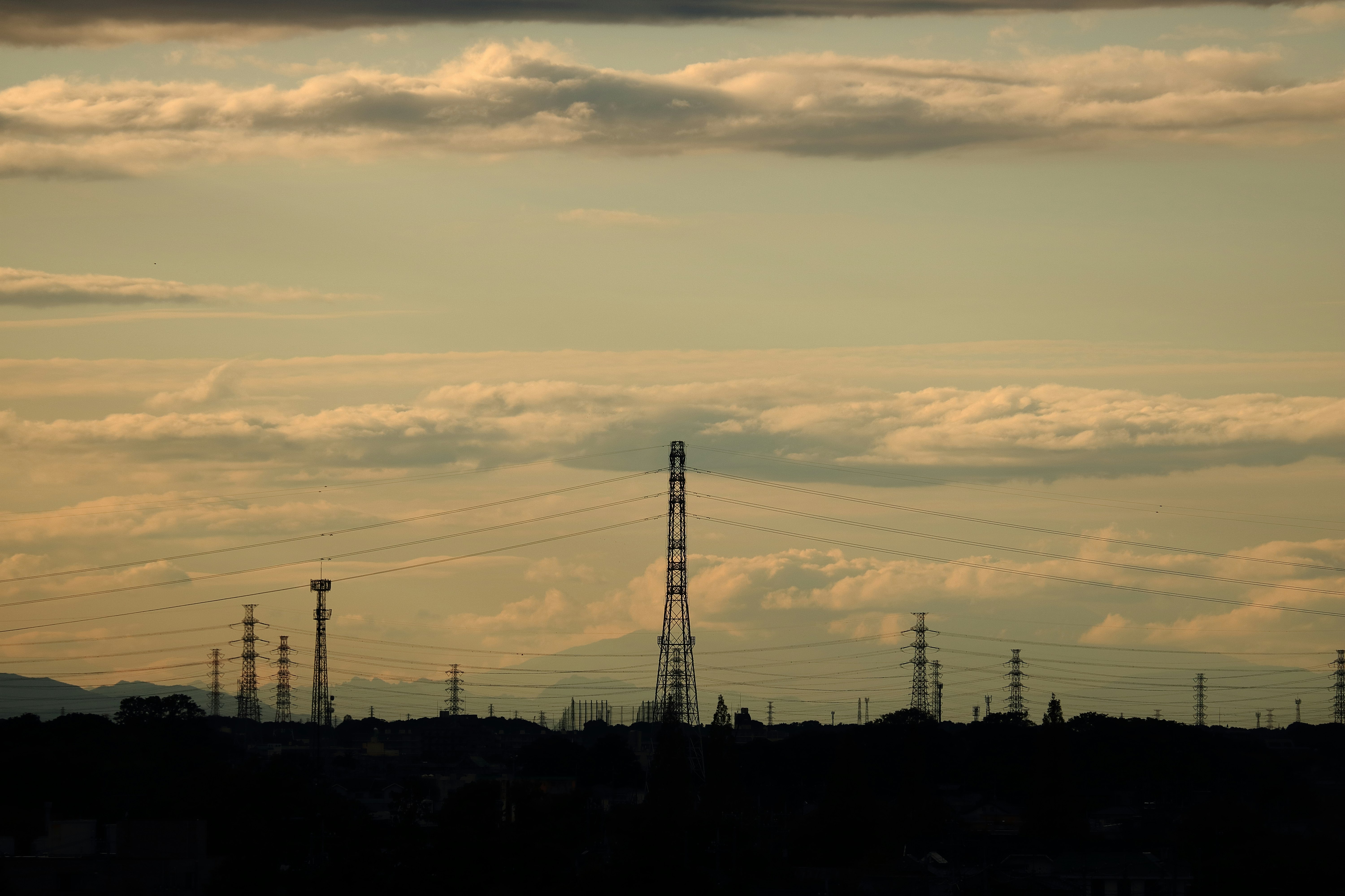 industrial skyline with power towers and smokestacks at dusk