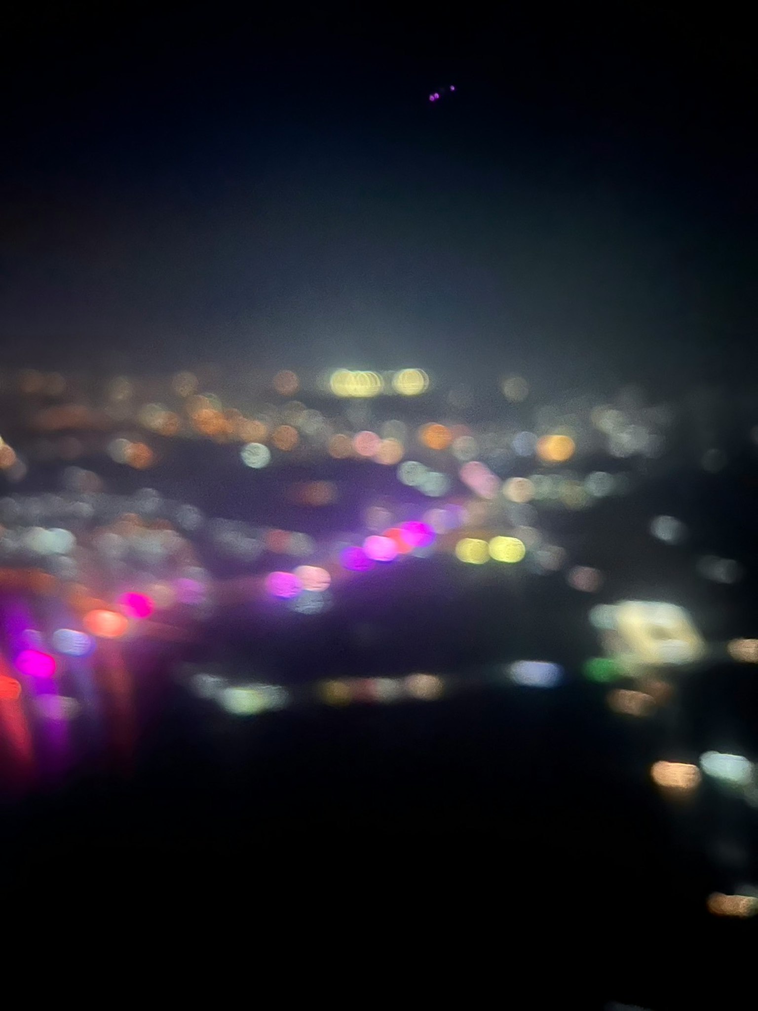 Immagine sfocata di un paesaggio urbano notturno con luci colorate e edifici illuminati