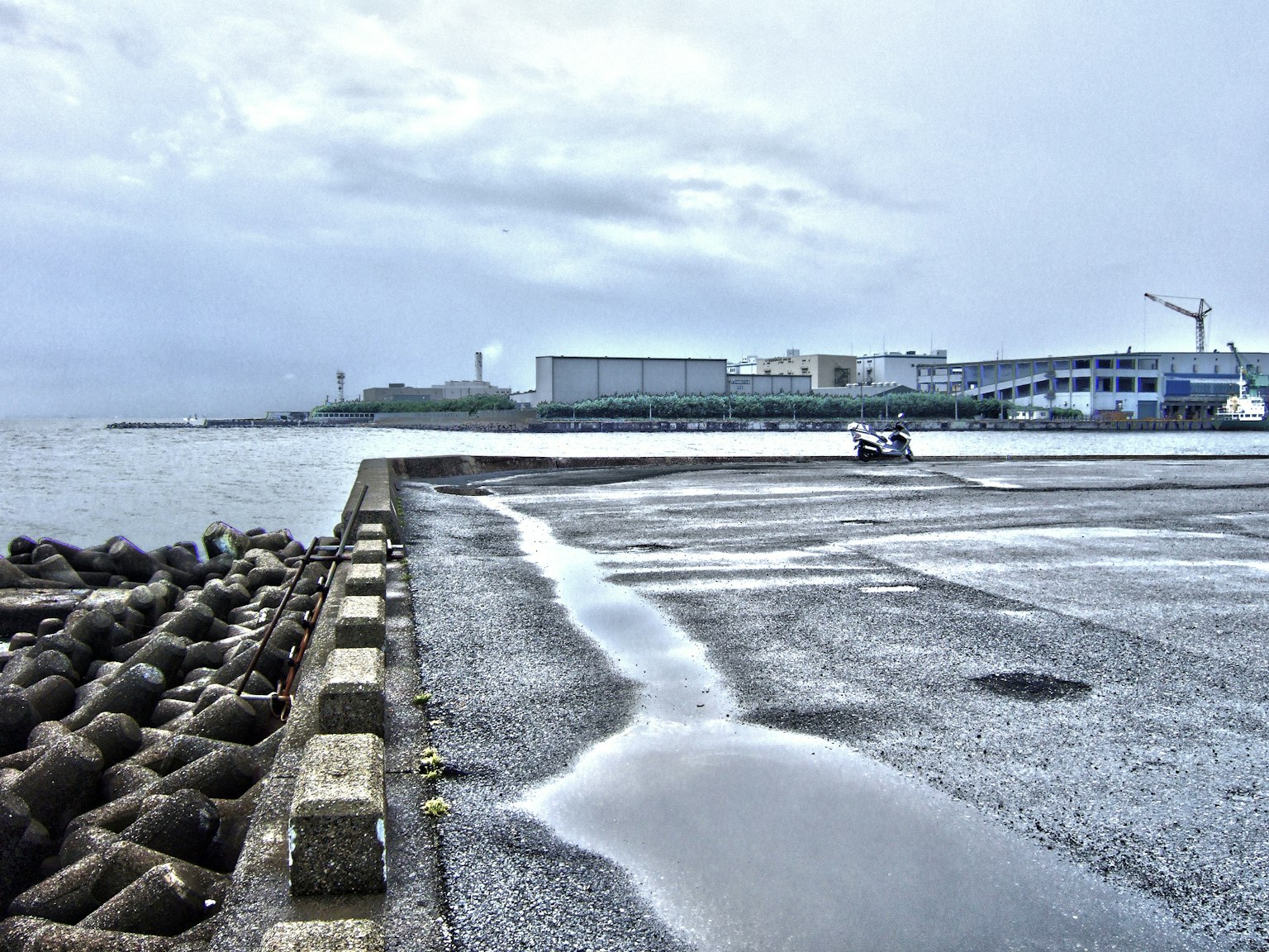 雨後港口場景，混凝土碼頭上的水坑和附近建築