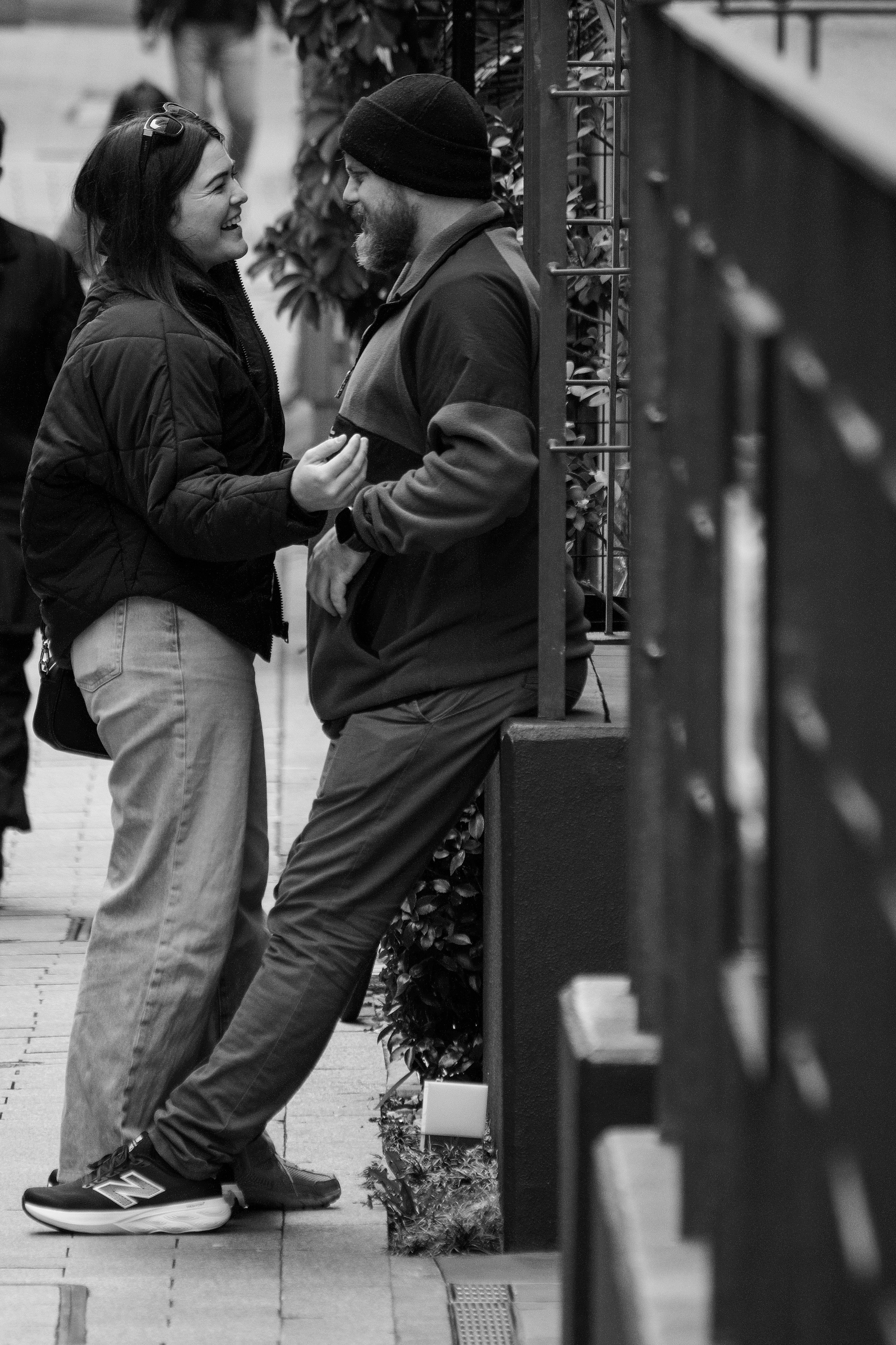 路地で微笑み合う2人のカップルの会話シーン